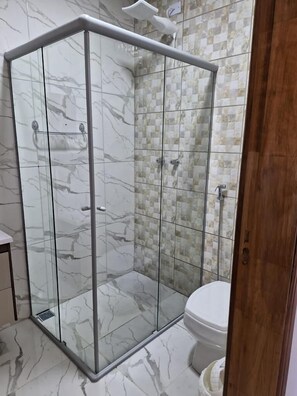 Habitación básica doble | Baño | Ducha, toallas y papel higiénico