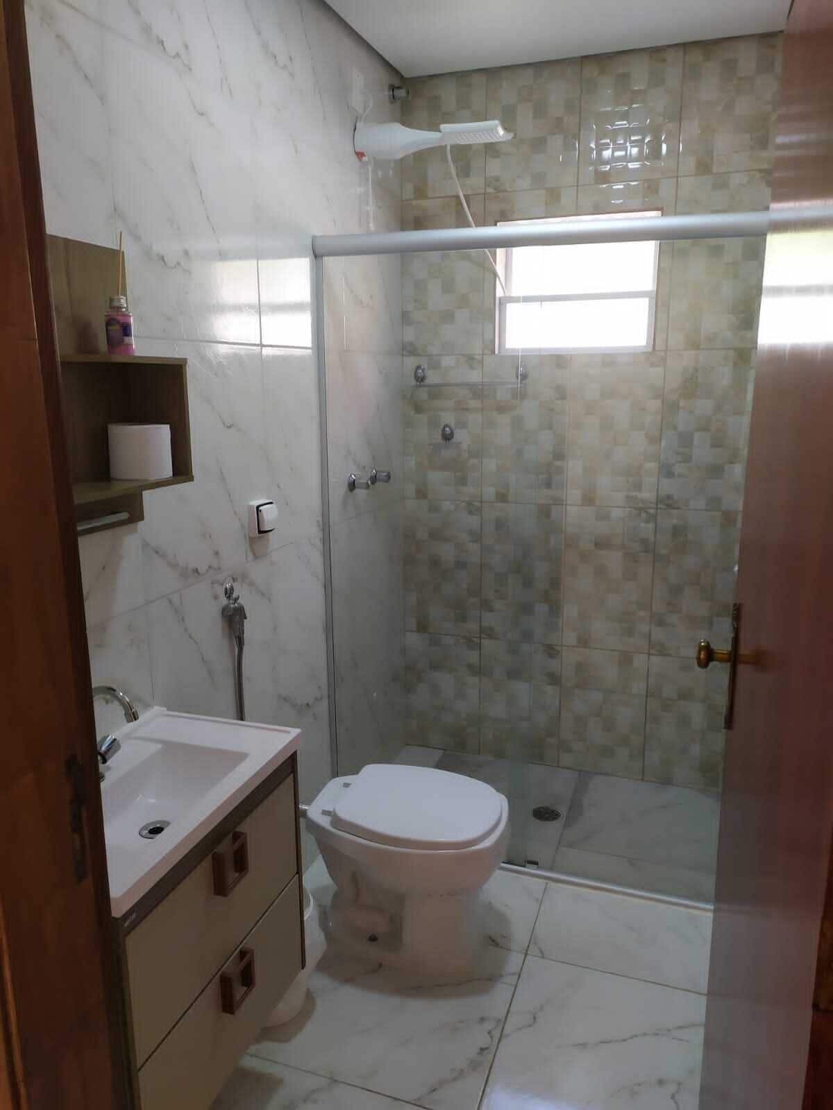 A bathroom with a toilet, sink, and shower area.