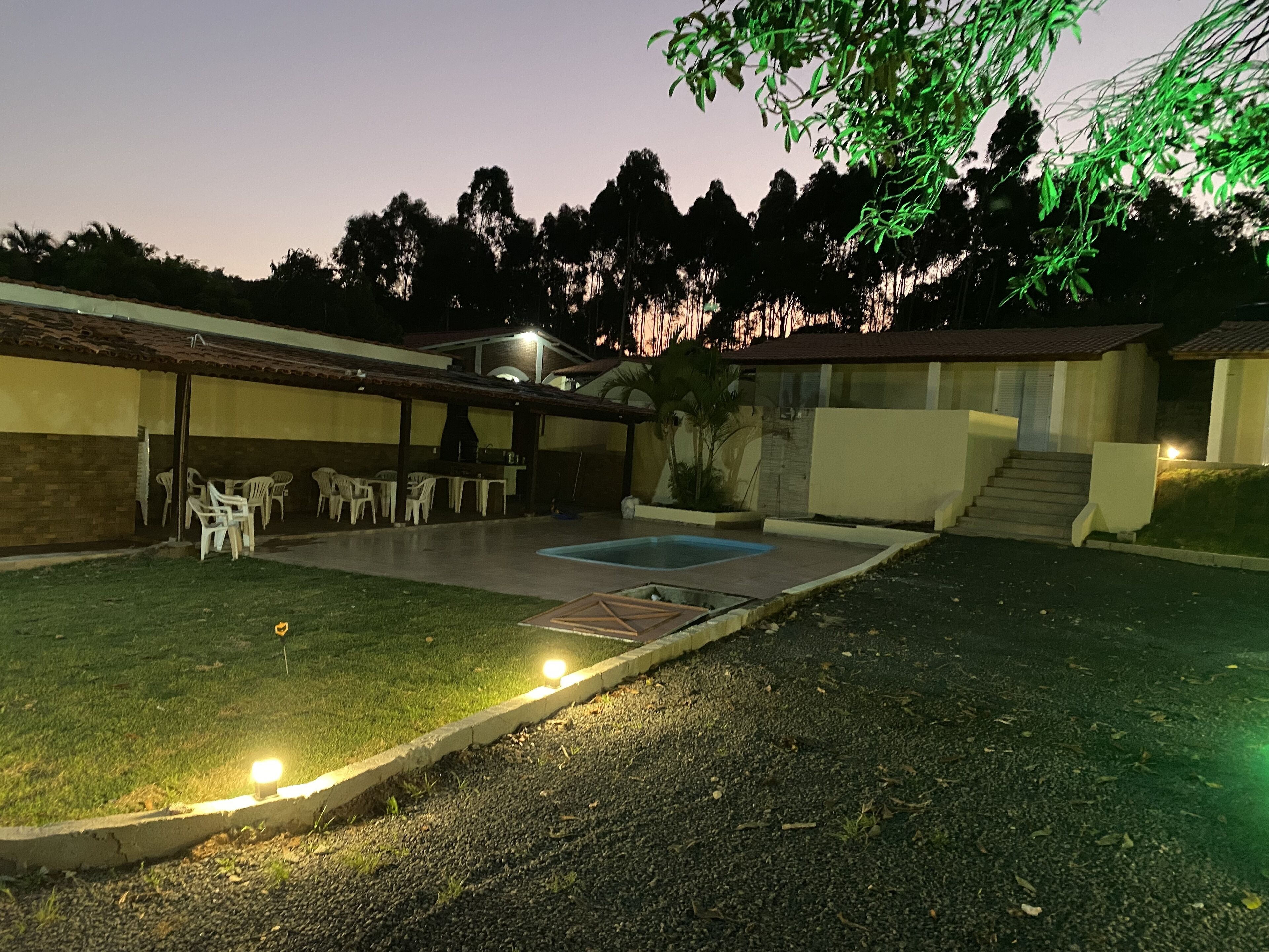 Un patio trasero con piscina, mobiliario exterior y zona de barbacoa.