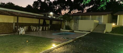 Un patio trasero con piscina, mobiliario exterior y zona de barbacoa.