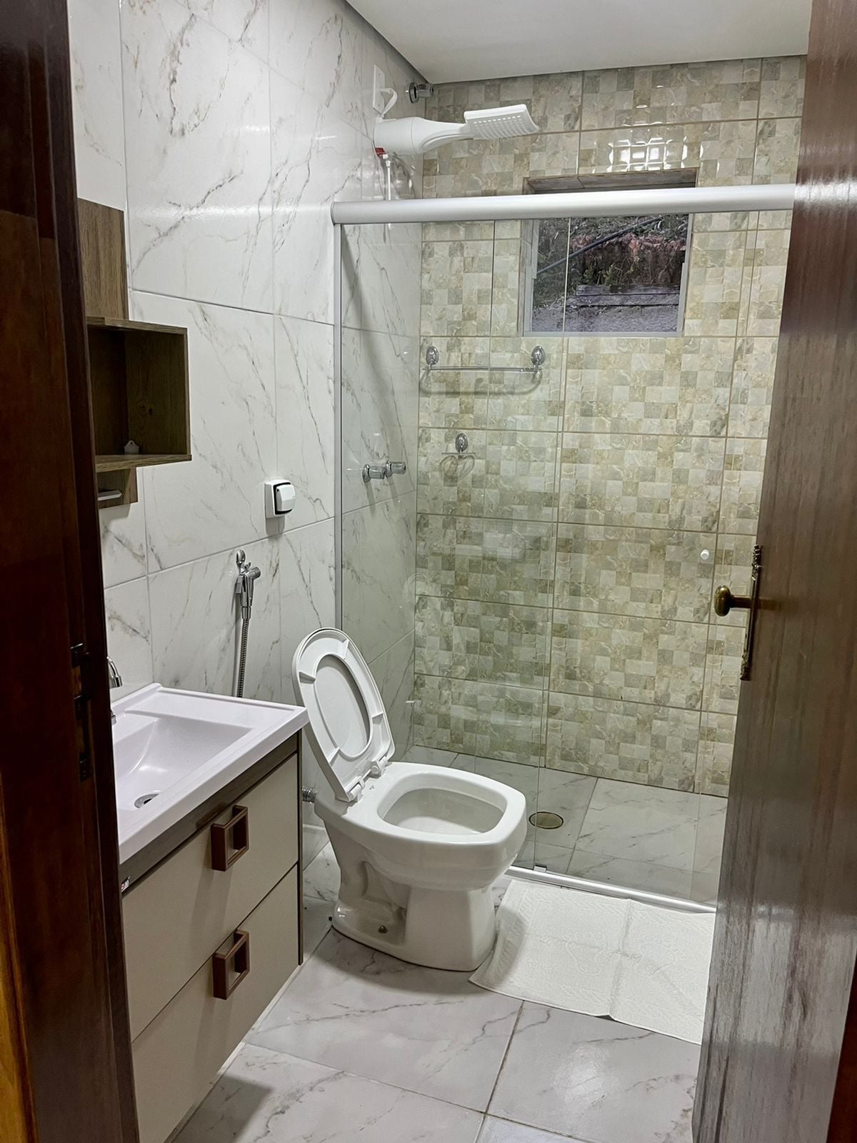 A bathroom with a toilet, sink, and shower area.
