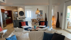 A modern living room with a sofa, coffee table, and a dining area in the background. - Rendez-vous in St-Martin - Tropical Waves (Sint Maarten)