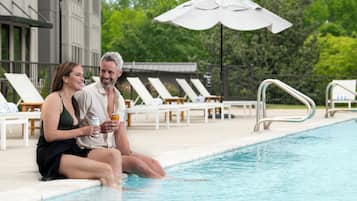 Una piscina al aire libre de temporada, sombrillas