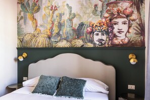 Un lit avec deux oreillers, une tête de lit et un tableau accroché au mur.