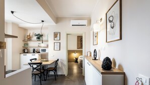 A modern kitchen with a dining area, a microwave, a coffee maker, and a small refrigerator. - Donna Rosa Holiday Home - Vicolo (Noto)
