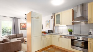 A modern kitchen with light-colored cabinets, a stainless steel oven, and a microwave. - Vacation apartment "Vahle 1" up to 4 persons (non-smoking) (Niendorf/Ostsee)