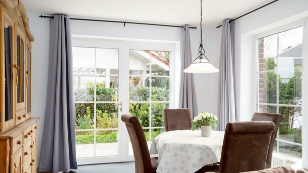 A dining area with a table, chairs, and a view of greenery outside. - Vacation apartment "Vahle 1" up to 4 persons (non-smoking) (Niendorf/Ostsee)