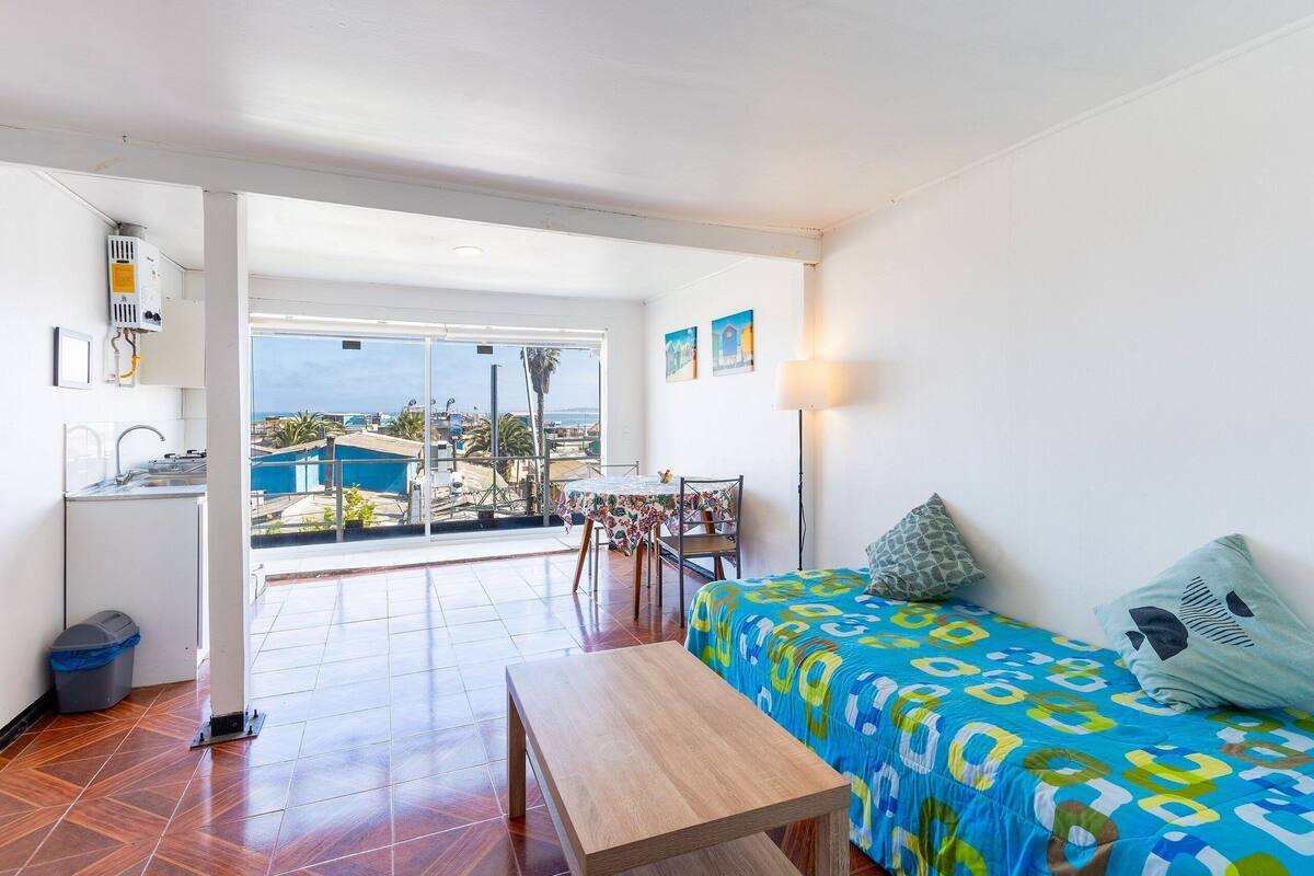 Ein Zimmer mit einem Bett, einem Tisch und Meerblick.
