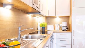 Une cuisine moderne dotée d’appareils électroménagers en acier inoxydable, de meubles en bois et d’un évier encastré.