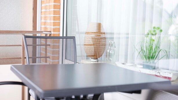 Un espace repas moderne comprenant une table, des chaises et un vase décoratif.
