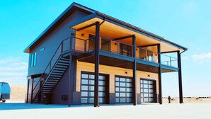 Een modern huis met twee verdiepingen, een balkon, grote ramen en een garage.