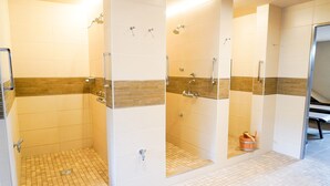 Un baño moderno con zona de ducha, inodoro y lavamanos.