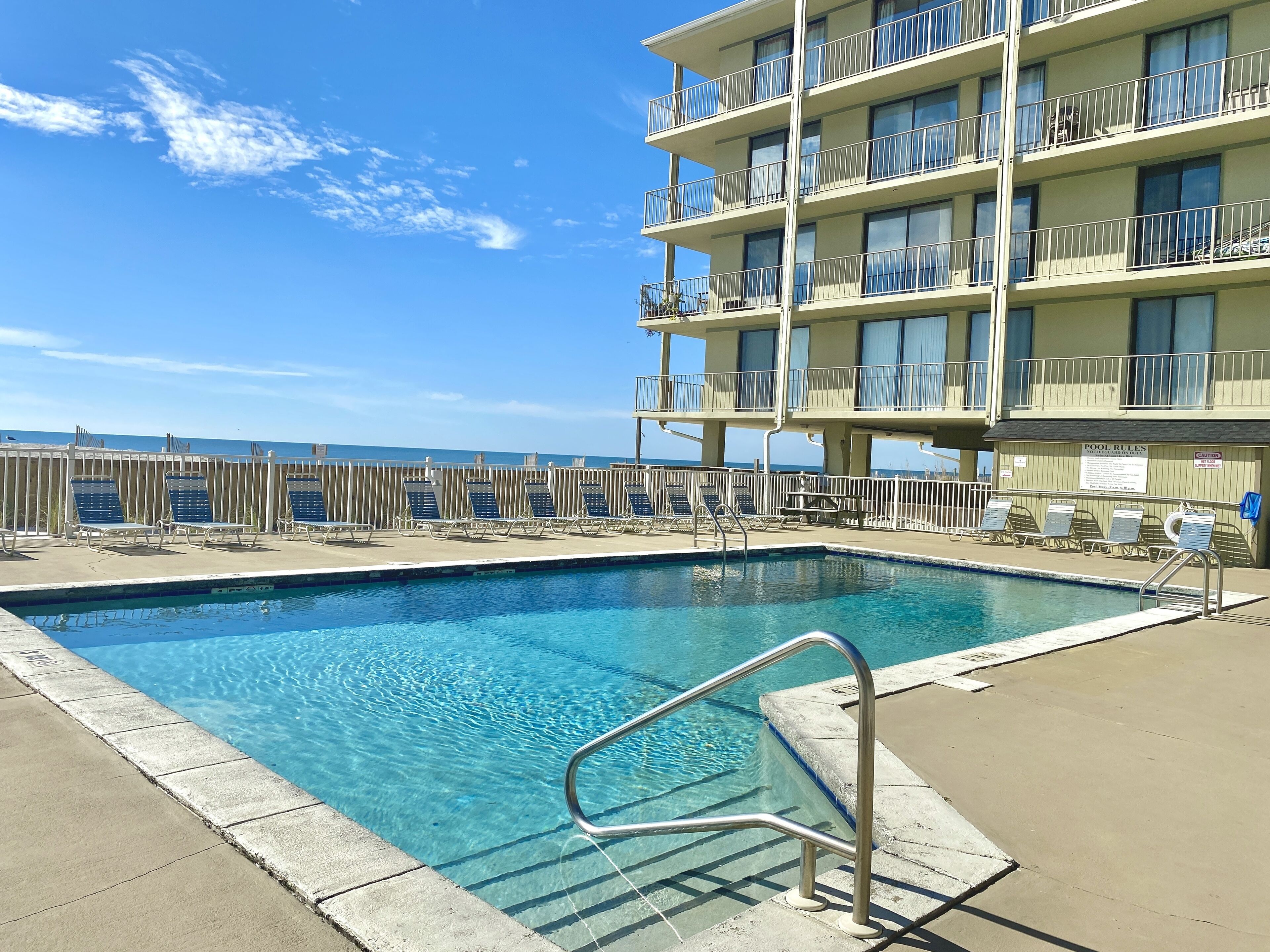 Una piscina al aire libre, sillones reclinables de piscina