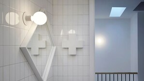 Ein modernes Interieur mit geometrischem Wanddesign, einer Treppe und einem Oberlicht.
