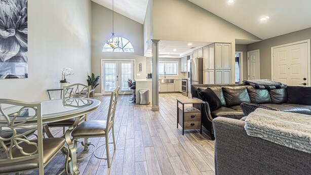 A spacious living area with a dining table, a sofa, and a kitchen in the background. - Modern Villa Retreat in Saddlebrook Resort (Zephyrhills)