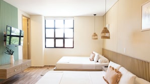 A modern bedroom with a large bed, a TV, and a window. - Mythical Hotel (Medellín)