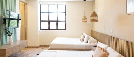 A modern bedroom with a large bed, a TV, and a window.