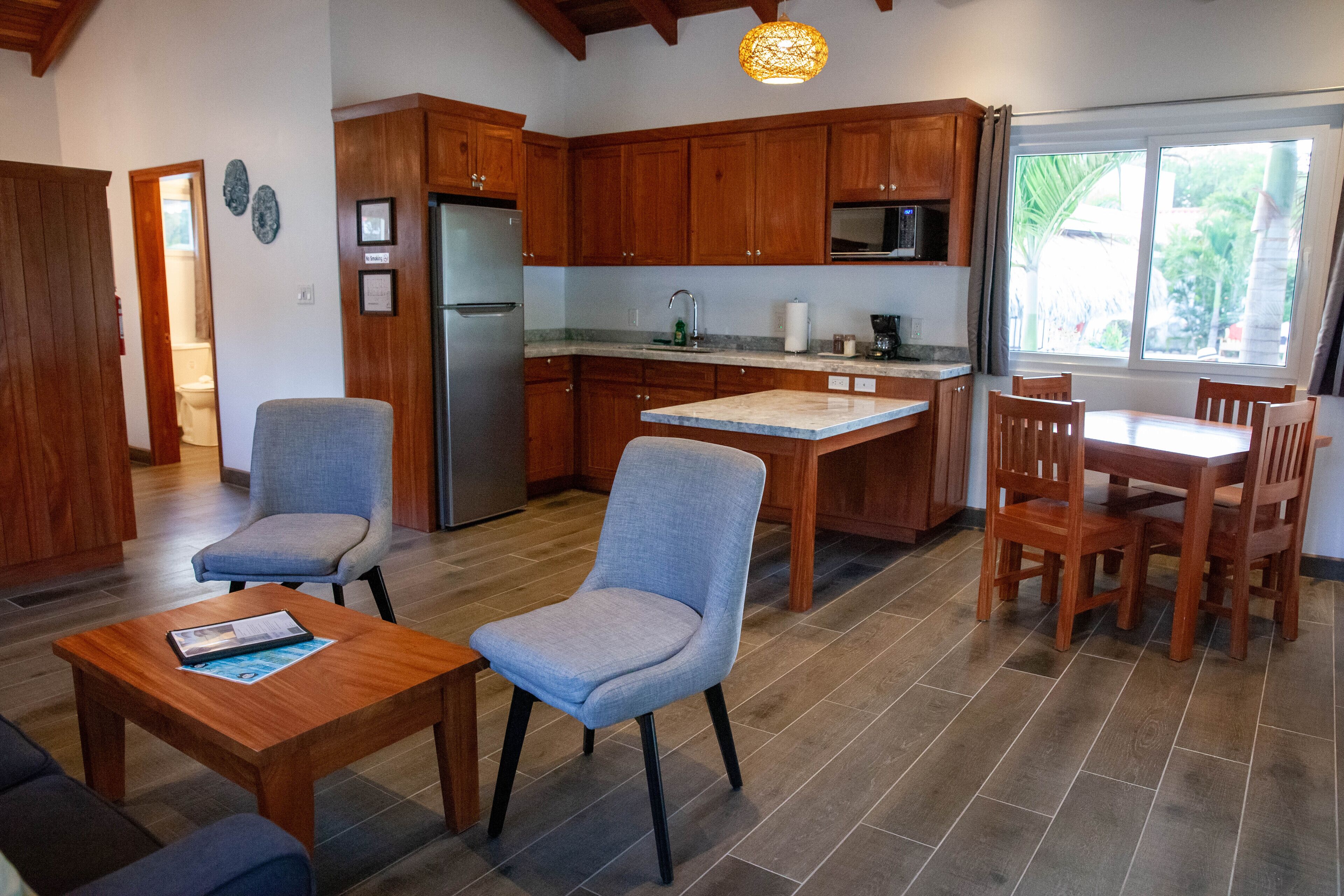 A spacious kitchen with wooden cabinets, a stainless steel refrigerator, and a dining area with a table and chairs.