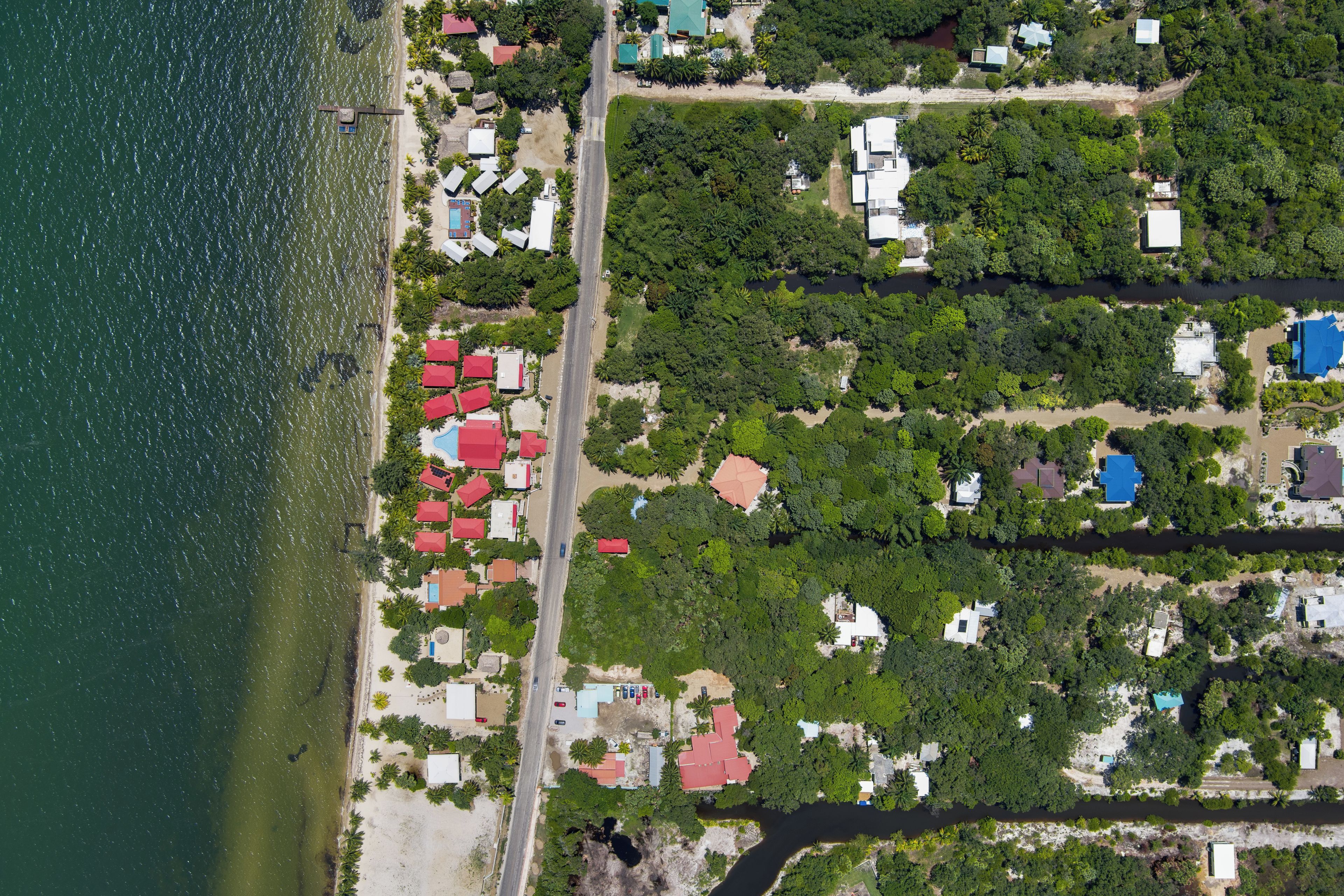 Vista aérea de una zona residencial costera con casas, una playa y un río.