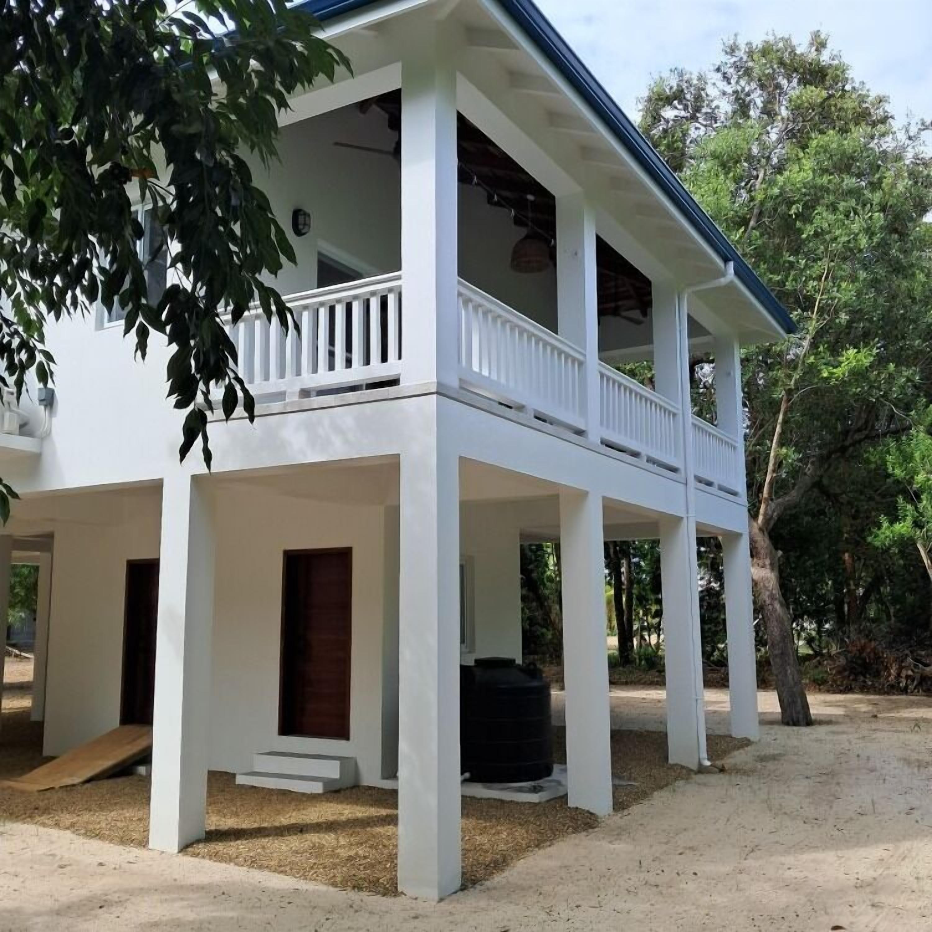 A two-story house with a balcony, a front porch, and a wooden door.
