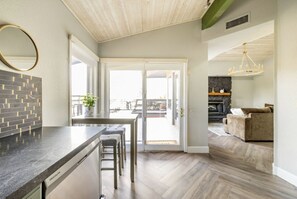 A modern kitchen with a built-in dishwasher, a dining area with a view, and a cozy living room with a fireplace. - Sedona Retreat! Private Deck/Views/Arcade/Golf/Spa (Sedona)