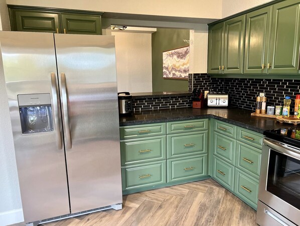 A kitchen with green cabinets, a stainless steel refrigerator, a toaster, and a stove. - Sedona Retreat! Private Deck/Views/Arcade/Golf/Spa (Sedona)