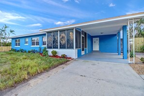 A blue single-story house with a covered porch and a front yard. - Modern Pool Home • Central Fort Myers Location (Fort Myers)