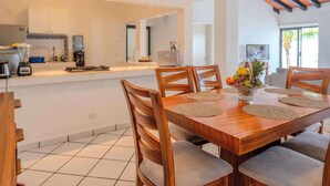 A modern kitchen with a dining area. - Oceanfront Luxury Condo w/ Pool & Balcony Views (Aguacate)