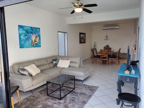 A living room with a sofa, coffee table, and a dining area with chairs and a table. - Oceanfront Villa: Private Resort w/ Heated Pools (Aguacate)