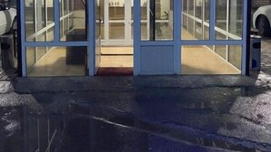 Het uiterlijk van Ikan Hotel met een glazen ingang en een bord erboven.