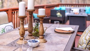 A dining table with candles, a bowl of blueberries, and a glass of water. - Acorn Ridge: Modern Shenandoah Mountain 4 Bedroom 4 Bathroom, Firepit, Theater (Basye)