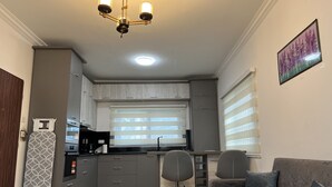 A compact living space with a kitchenette, a dining area, and a sofa. - Quiet escape, good security and serene environment (Accra)