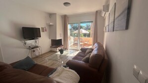A living room with a TV, sofa, and a glass coffee table. - NEW LAUNCH!!! Wyndham Beach and Pools Resort in La Cala, Mijas & Fuengirola (Las Lagunas de Mijas)