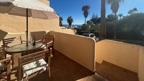 A patio with a table, chairs, and an umbrella. - NEW LAUNCH!!! Wyndham Beach and Pools Resort in La Cala, Mijas & Fuengirola (Las Lagunas de Mijas)