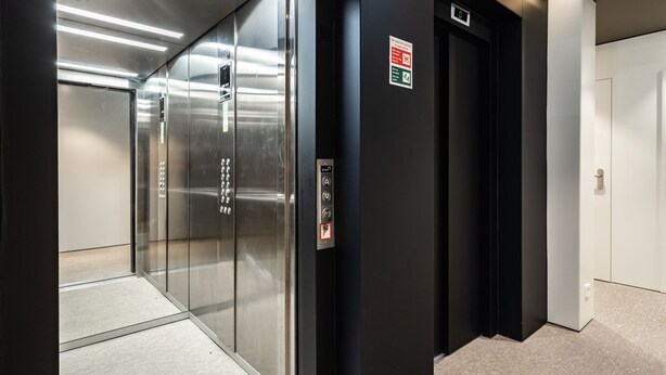 An elevator with a digital display, emergency instructions, and a control panel.
