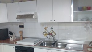 A kitchen with white cabinets, a stainless steel sink, a stove, and a dishwasher. - One step away (Arezzo)