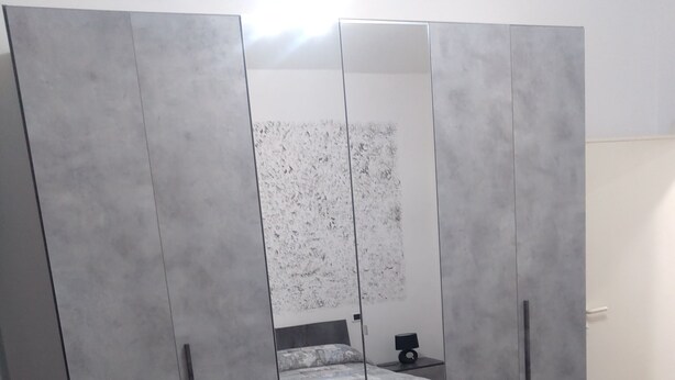 A bedroom with a bed, a wardrobe, and a mirror. - One step away (Arezzo)
