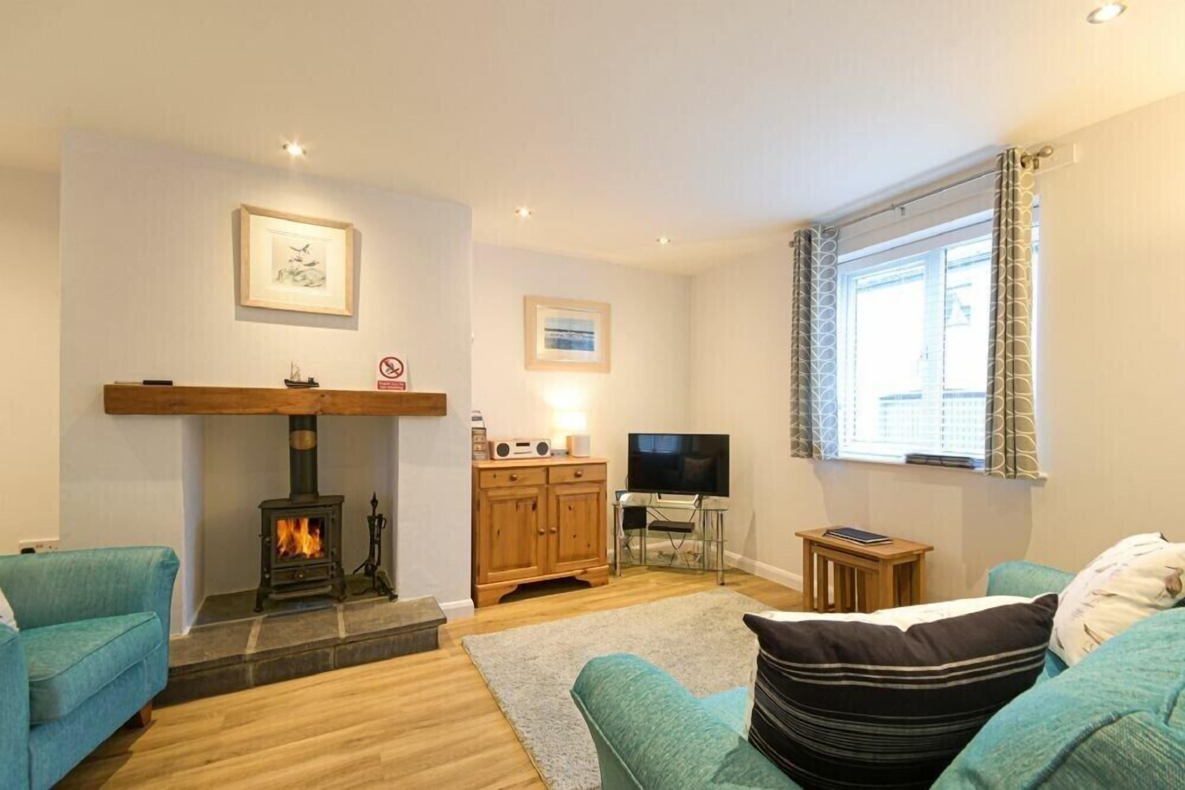 Ein gemütliches Wohnzimmer mit Kamin, Fernseher und zwei Sofas.