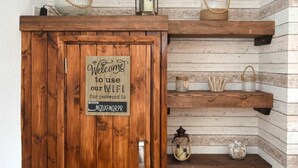 Ein Holzkabinet mit einem Schild, auf dem steht: 'Willkommen, nutzen Sie unser WLAN. Unser Passwort ist MQDFXMQRPR'.