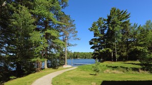 A pathway leading to a lake surrounded by trees.