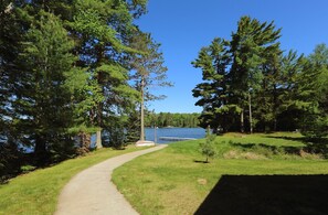 A pathway leading to a lake surrounded by trees.
