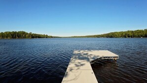 A wooden dock extending into a calm lake with a clear sky above. - Liam's Landing located on Little St Germain Lake (St Germain)