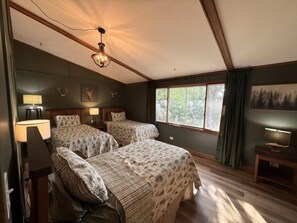 A bedroom with two beds, a wooden ceiling, and a window with curtains. - Liam's Landing located on Little St Germain Lake (St Germain)