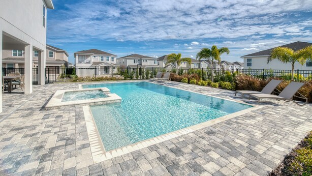 A rectangular swimming pool with a tiled deck, surrounded by lounge chairs and palm trees. - Encore Luxe 9 BR, Home Theater, Private Pool & Spa (Four Corners)