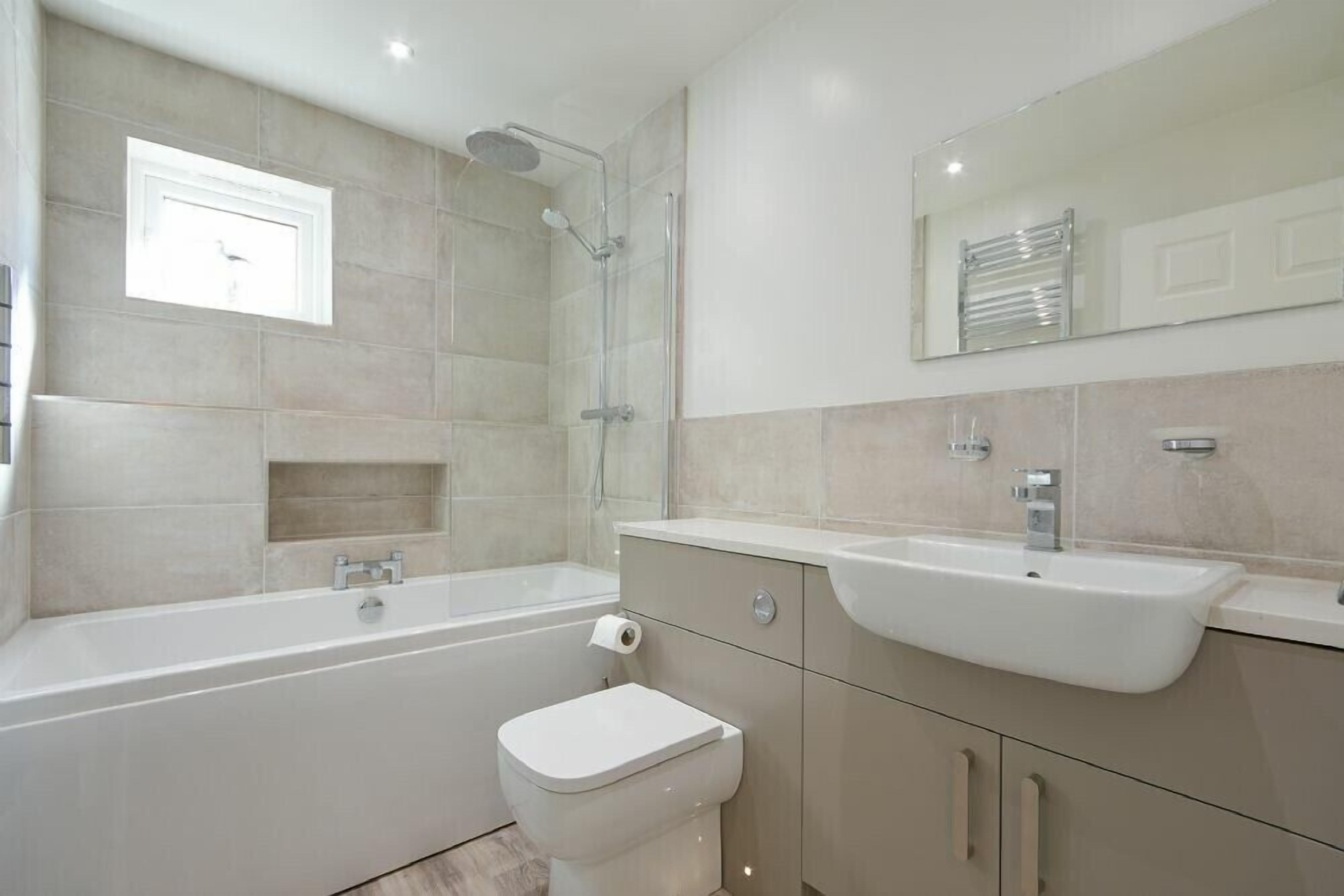 Un baño moderno con bañera, inodoro, lavabo y ducha.
