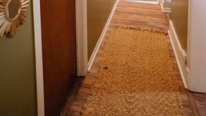 A hallway with a wooden door, a white door, and a rug on the floor. - Beautiful One Bedroom Apartment in The Neighbor of the Art (Rochester)