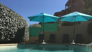 A clear swimming pool with two blue umbrellas and lounge chairs. - VILLA WITH HEATED POOL and ocean view - Margaux Villa (Propriano)