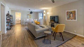 A modern living room with a sofa, chairs, a TV, and a ceiling fan. - Renovated Home in Historic Downtown Durango (Durango)