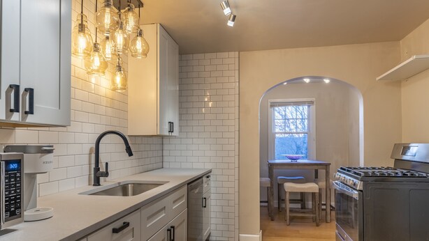 A modern kitchen with white cabinetry, a built-in oven, and a coffee maker. - Renovated Home in Historic Downtown Durango (Durango)