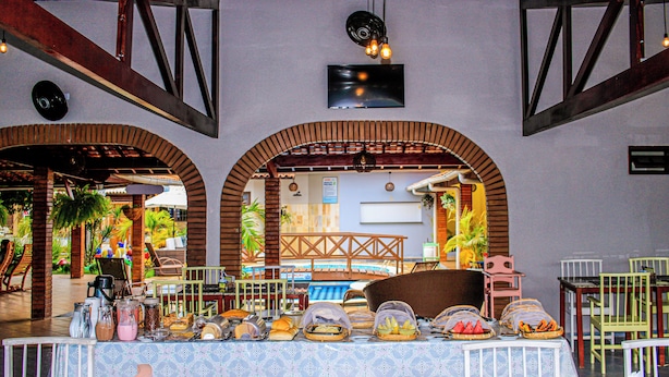 Un restaurante con barra libre, que ofrece una variedad de comidas y un área de asientos con sillas y mesas.